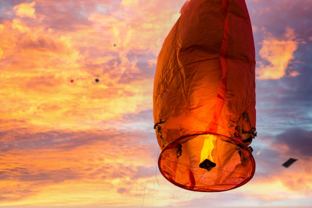 Burnt damaged sky lantern against a blue sky filled with kites in Jaipur on Makar Sankranti