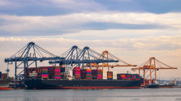 istock Logistics and container loading by large barges by sea in a harbor full of containers waiting to be transported 1200327720