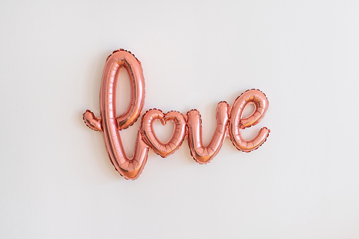 Pink foil balloon - word LOVE - on white background