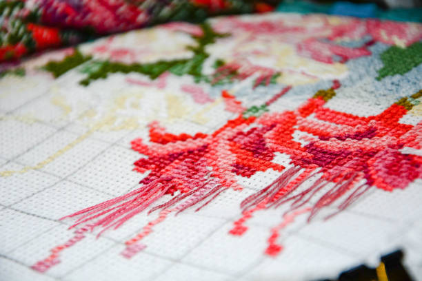 istock The process of embroidery. White canvas. Colored threads. Cross-stitch. Close-up. 1200331815