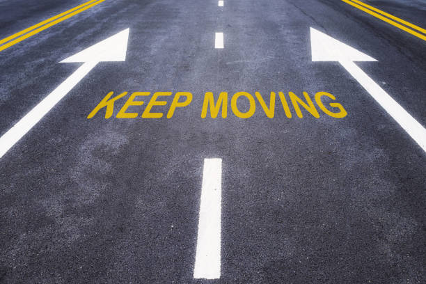istock Keep moving word with yellow line marking on road surface 1200333507