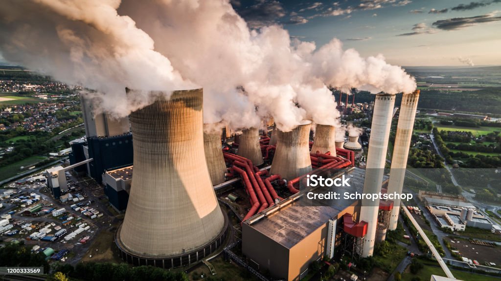Aerial view of a power station Aerial view of building exterior of a coal fired power station. Large cooling towers emitting steam into to air. Great for global warming, climate change and pollution themes. Greenhouse Gas Stock Photo