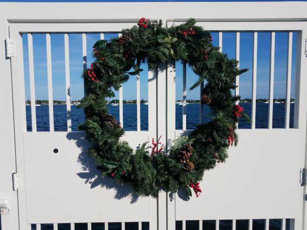 istock circular holiday wreath on white fence and water 1200334388