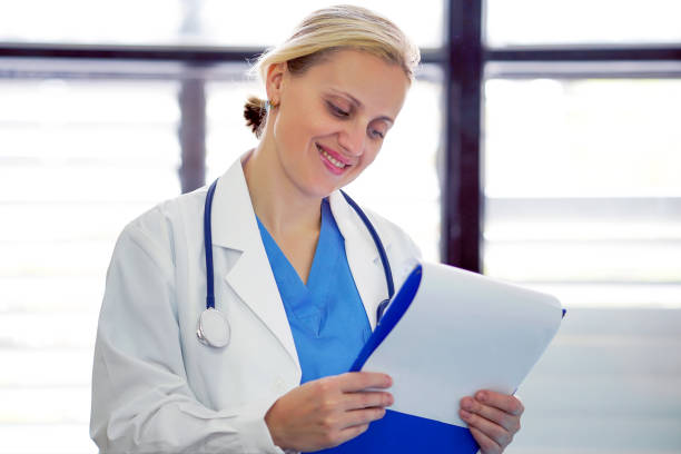 istock Cheerful female doctor is holding documents with patient information in office 1200334937