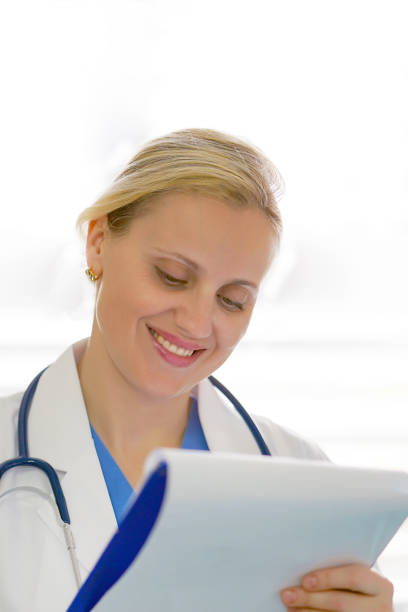 istock A female doctor with a folder isolated on white background. 1200335636