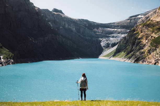 mujer excursionista mirando el hermoso lago y las montañas en los alpes suizos - switzerland hiking boot outdoor pursuit recreational pursuit fotografías e imágenes de stock