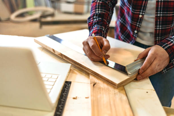 istock Close up of unrecognizable worker drawing on wood plank 1200337397