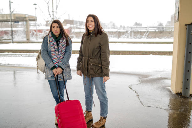 istock Two friends talking and waiting train in railway station 1200338835