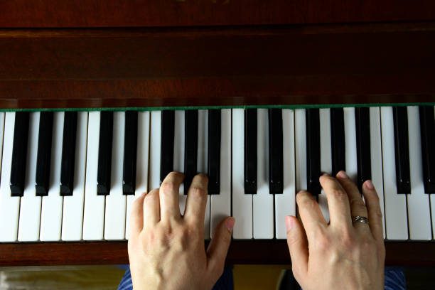istock Woman hands playing the piano in view from above 1200341841