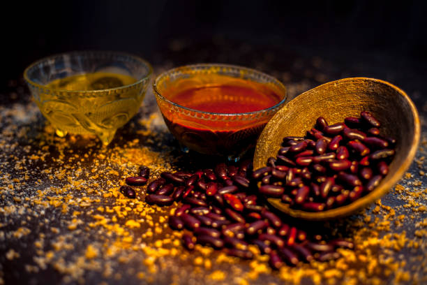 Home pore remedy on the black glossy surface consisting of some red beans or kidney beans mung beans and some green tea. Well mixed together in a bowl. Face mask for pore prevention.Horizontal shot. remedio de poro casero en la superficie brillante negro que consiste en algunos frijoles rojos o frijoles frijoles mung frijoles y un poco de té verde. bien mezclados en un tazón. máscara facial para la prevención de poros. disparo horizontal.