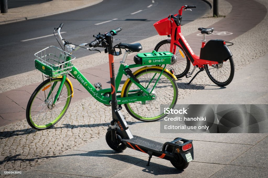 Bike-Sharing-Fahrräder und Elektroroller, Escooter oder E-Scooter auf dem Bürgersteig - Lizenzfrei Elektro-Tretroller Stock-Foto