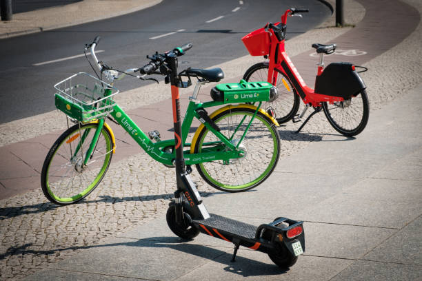 Bike sharing bicycles and electric scooter , escooter or e-scooter on sidewalk Berlin, Germany - June, 2019: Bike sharing bicycles and electric scooter , escooter or e-scooter on sidewalk in Berlin, Germany lime scooter stock pictures, royalty-free photos & images