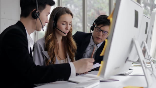 young beautiful women call center wear headset brainstorming with co-worker while consulting customer with online problem. operator service business representative concept. online marketing.