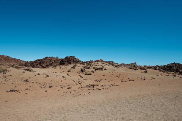 istock desert landscape with volcanic rocks and clear blue sky copy space - 1200348781