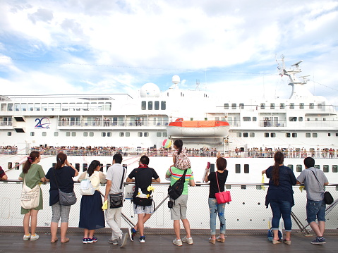 Yokohama, Japan - August 16th, 2018: People celebrating the departure of cruise ship Pacific Venus at the Osanbashi Pier in Yokohama.