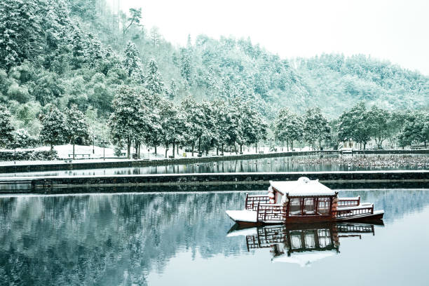 Pond in Xidi village, China A pond and a small boat in the ancient village of Xidi in the Anhui province of China in winter under snow anhui province stock pictures, royalty-free photos & images