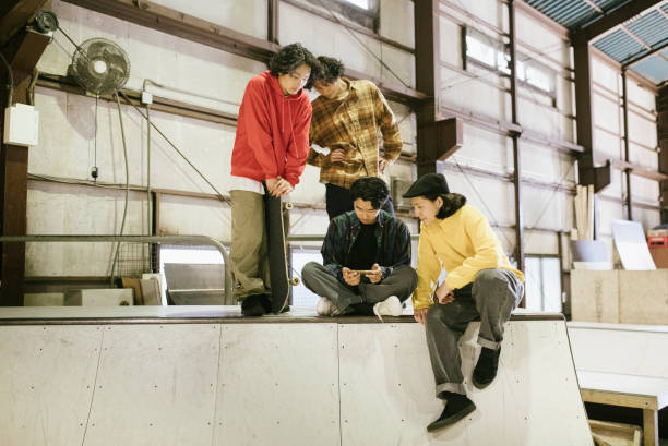 istock Group of skateboarders watching video from a smartphone. 1200356167