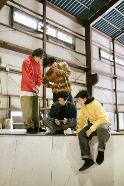 istock Group of skateboarders watching video from a smartphone. 1200356183
