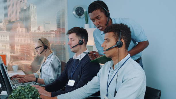 istock Black manager operator helping his colleague in call center 1200357956