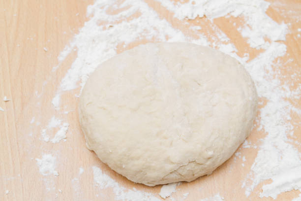 istock Prepared kneaded dough on a wooden table at home 1200358460
