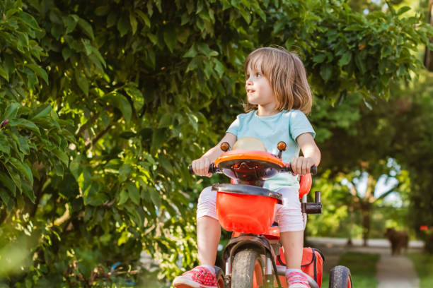 istock Cute little girl riding tricycle. 1200366412