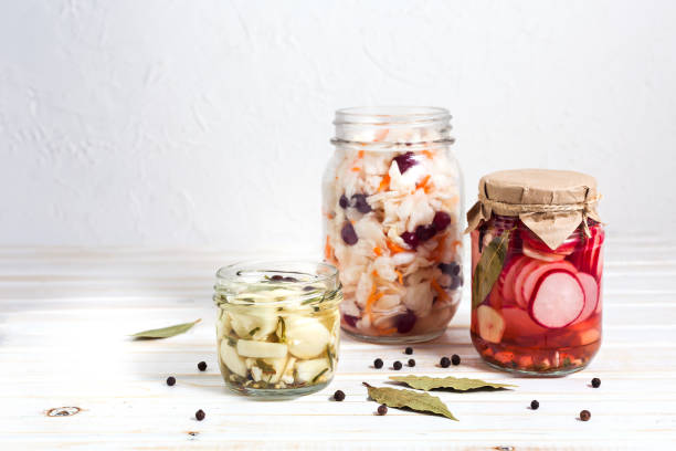 istock Fermented vegetables, pickled Cabbage, radish and garlic in a glass jaron on a light background with copy space. Horizontal orientation 1200368935