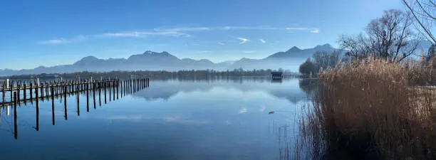 Foggy day on Chiemsee Lake in Bavaria - hut and mountains reflecting in water