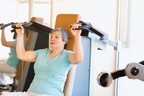 istock octogenarian senior woman exercising in gym 1200375239