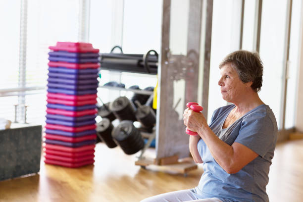 istock octogenarian senior woman exercising in gym 1200375261