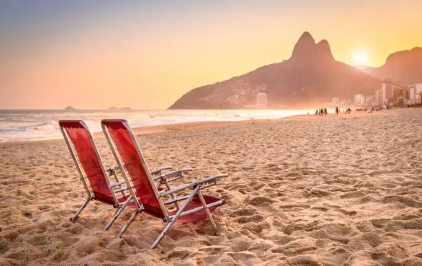 Beach deck chair against a backdrop of Two Brothers Mountain in Rio de Janeiro, Brazil at sunset