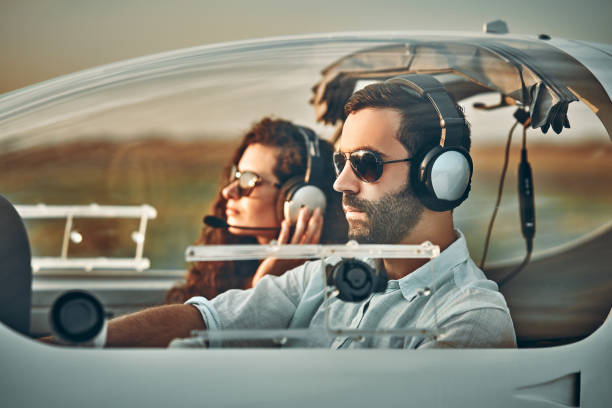 istock Young pilot and beautiful stewardess sitting together inside airplane cabin waiting for take off 1200382176