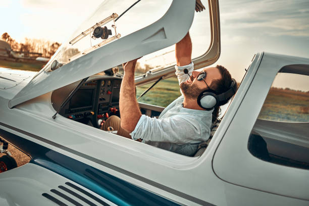 Young pilot is preparing for take off with private plane Young pilot is preparing for take off with private plane. piloting stock pictures, royalty-free photos & images