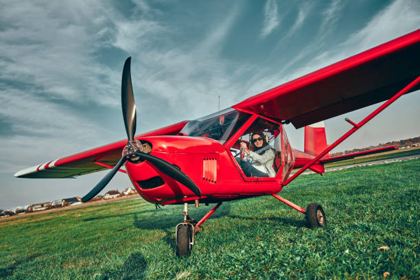 pequeño avión privado aterrizó en el campo con el piloto en una cabina - landed airplane travel commercial airplane fotografías e imágenes de stock