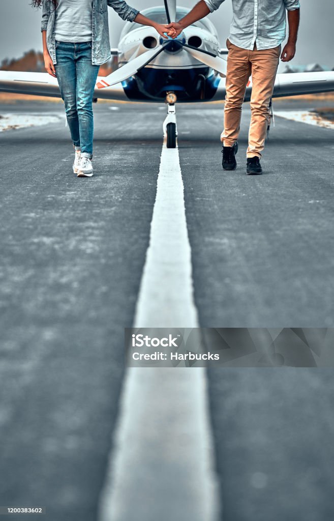 Pareja Sosteniendo La Mano Caminando En La Pista Foto de stock y más banco de imágenes de Avión - Avión, Familia, Secreto - iStock Pareja Sosteniendo La Mano Caminando En La Pista Foto de stock y más banco de imágenes de Avión - Avión, Familia, Secreto - iStock