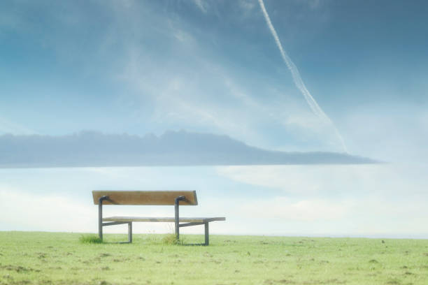 Lonely empty bench in open tranquil landscape by the sea for mindfulness and meditation uk