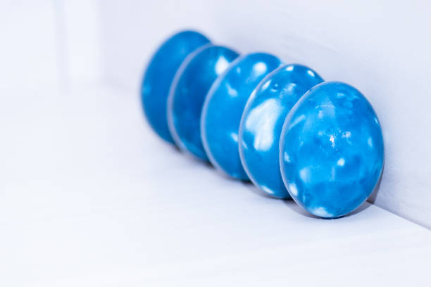 Five blue space galactic Easter eggs on white wooden background. Close up. Easter greeting card. Copy space.