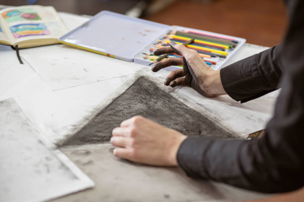 istock Hands of a young artist working on charcoal drawing 1200387829