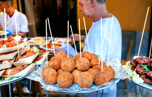 Palermo, Italy: Arancini for hungry customers of street market, tasty stuffed rice balls, traditional Sicilian snack on 10 October 2019. Sicily is Italian region with highest number of expatriates