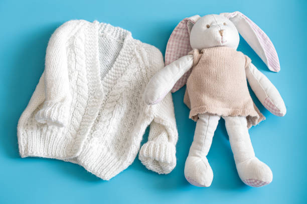 istock Knitted baby clothes and accessories on a blue background . 1200388832