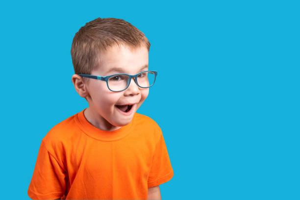 istock Little boy in glasses is very surprised. Isolated on a blue background. 1200390678