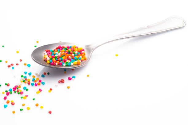istock Sugar sprinkles on spoon over white background 1200391830