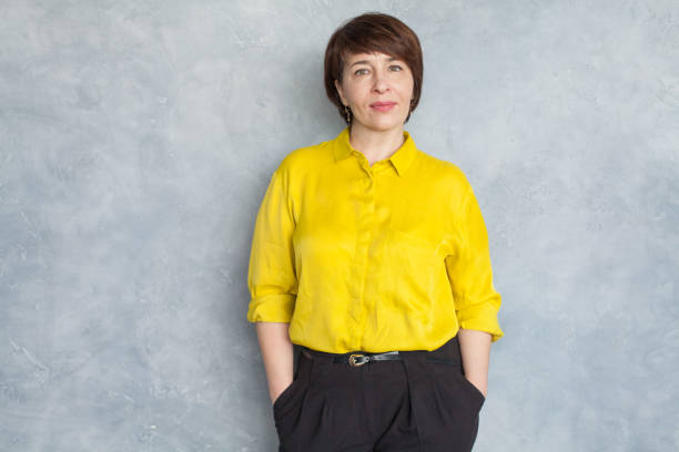 smart business woman wearing yellow shirt. mature woman 45 years old - 40 44 years imagens e fotografias de stock