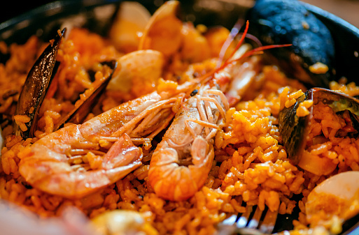 Shrimps and sea mussels in paella, traditional Mediterranean food in a restaurant plate. Seafood.