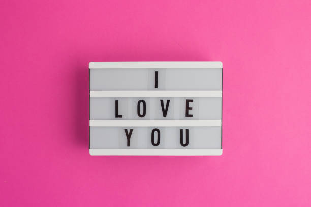 istock I Love you text on white lightbox. Pink background with box. Flat lay style. Top view 1200393813