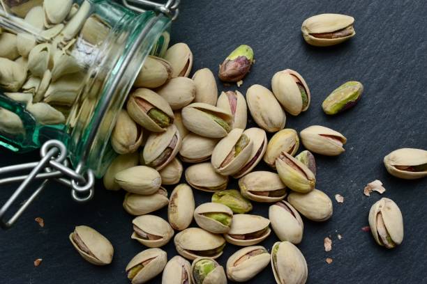 Pistachios Pistachios on a dark background Pistachio stock pictures, royalty-free photos & images