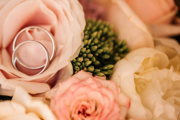 istock Wedding rings on a bridal bouquet, closeup shot 1200395478