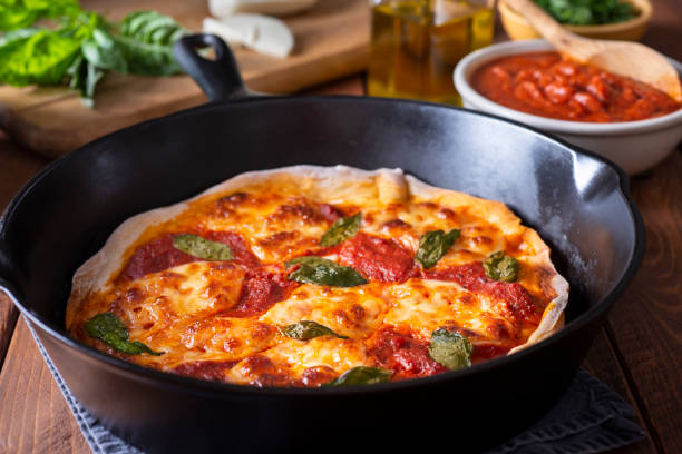 Skillet Pizza Margharita Pizza in a Cast Iron Skillet skillet cooking pan photos stock pictures, royalty-free photos & images