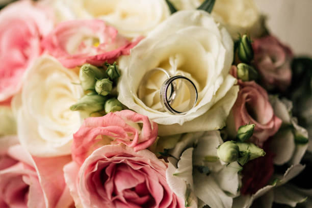 istock Wedding rings on a flowers 1200400575