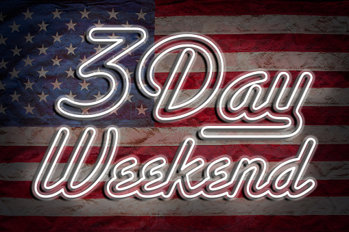 Three Day Weekend neon sign with US flag in background.