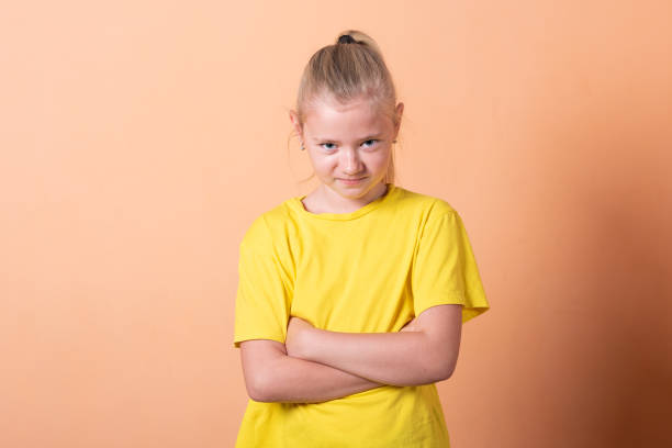 istock The girl put her hands on her hips, on a light orange background. 1200402515